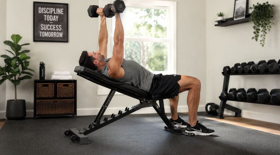 Homme effectuant un dvelopp couch avec haltres sur un banc de musculation pliable  domicile