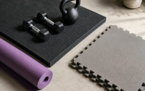 Trois types de tapis de sol pour home gym : tapis caoutchouc épais, tapis de yoga et dalles puzzle EVA avec haltères